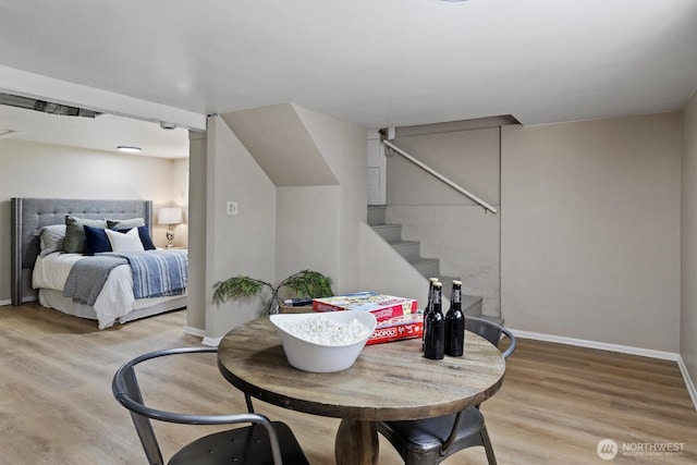 dining area featuring wood finished floors, baseboards, and stairs