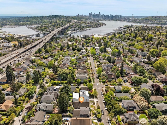aerial view of residential area featuring a notable bridge, a large body of water, a skyline view, and a main thoroughfare