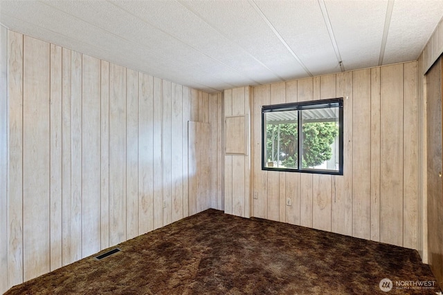 1402 22nd St NE Unit 406, Auburn, WA 98002 - carpeted empty room featuring wood walls and a textured ceiling