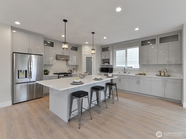 23801 100th Ave SE, Kent, WA 98031 - kitchen with stainless steel appliances, gray cabinetry, under cabinet range hood, a breakfast bar, and recessed lighting