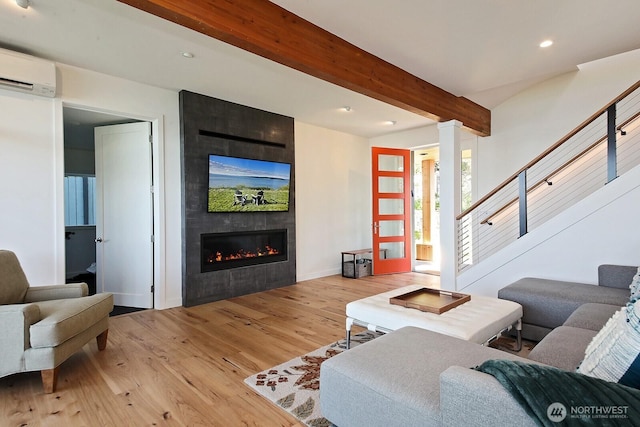 3139 Saratoga Rd, Langley, WA 98260 - living room with an AC wall unit, beamed ceiling, a fireplace, wood finished floors, and recessed lighting