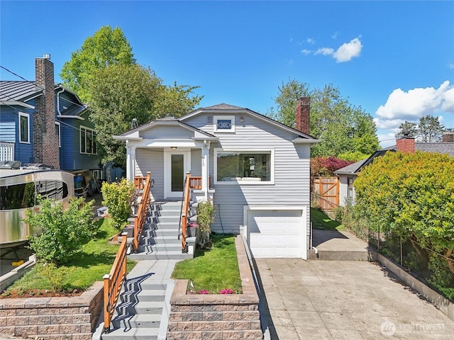 bungalow-style home featuring an attached garage, concrete driveway, fence, stairway, and a chimney