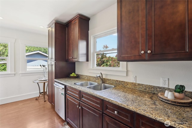 kitchen with a sink, dishwasher, healthy amount of natural light, and light wood-style flooring