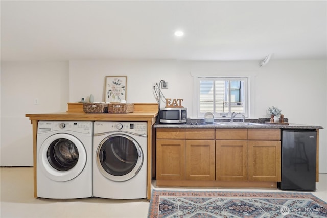 laundry area with separate washer and dryer and a sink