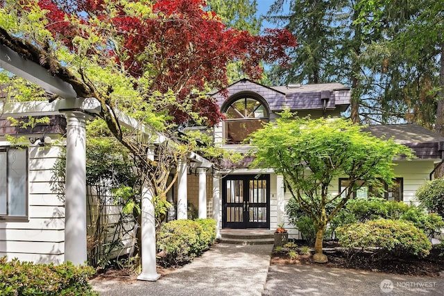 view of front facade with french doors and roof with shingles