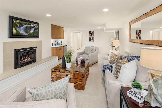 living area featuring light colored carpet, recessed lighting, and a high end fireplace