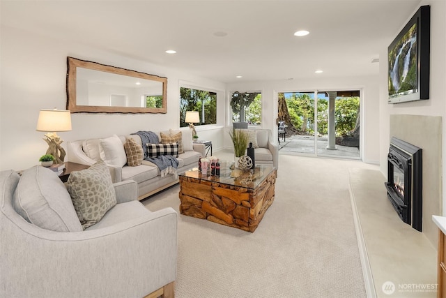 carpeted living area featuring recessed lighting and a glass covered fireplace