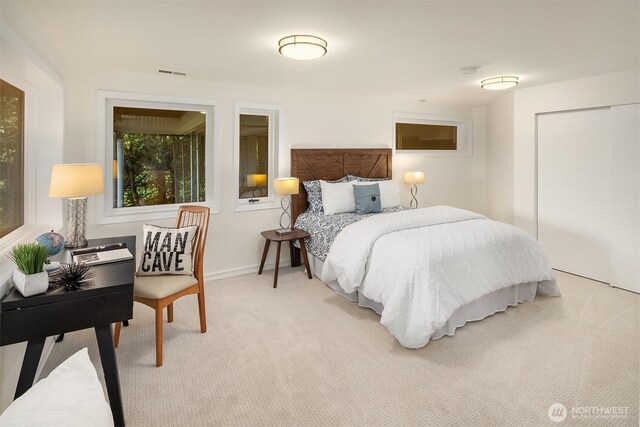 bedroom with light carpet and a closet