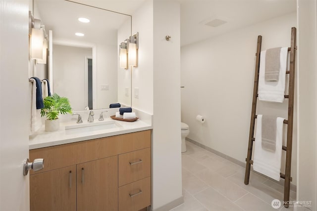 bathroom featuring toilet, vanity, recessed lighting, tile patterned floors, and baseboards