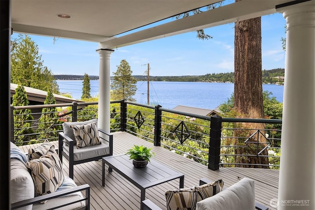 wooden deck with a water view and an outdoor living space