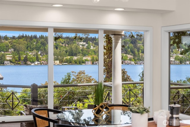 sunroom / solarium featuring a water view and view of scattered trees