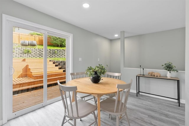 dining room featuring light wood-style flooring, recessed lighting, and baseboards