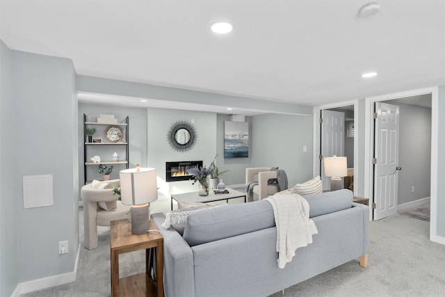 living room featuring a glass covered fireplace, carpet flooring, recessed lighting, and baseboards