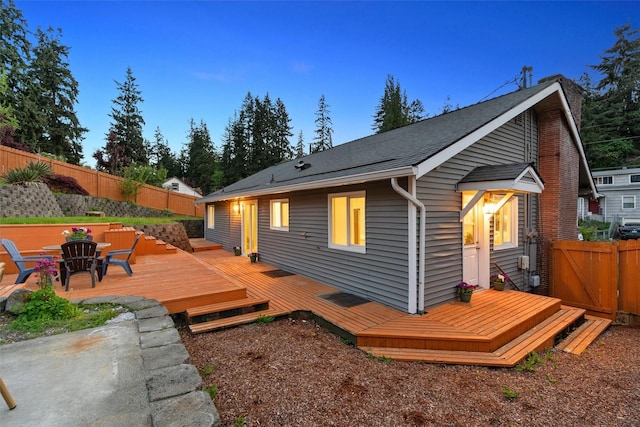 rear view of property featuring a fenced backyard and a wooden deck