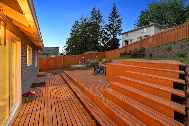 deck featuring outdoor dining area and a fenced backyard