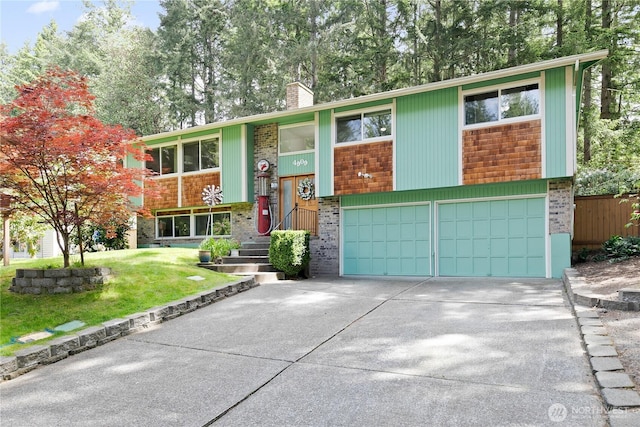 4909 95th Ave W, University Place, WA 98467 - split foyer home featuring brick siding, a chimney, concrete driveway, an attached garage, and a front lawn