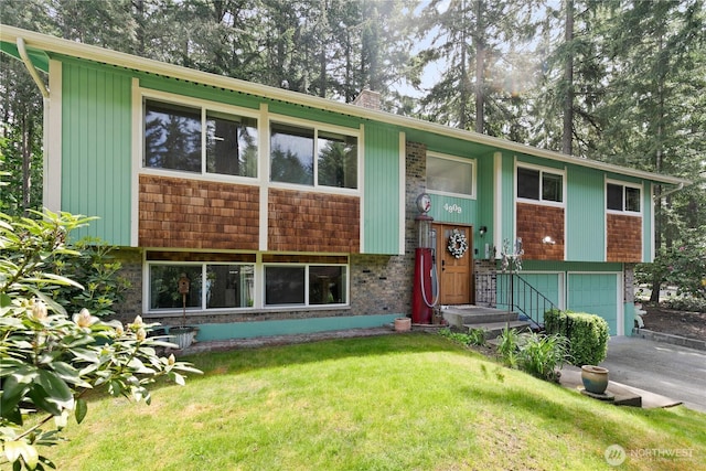 4909 95th Ave W, University Place, WA 98467 - raised ranch with a garage, a front lawn, a chimney, driveway, and view of wooded area