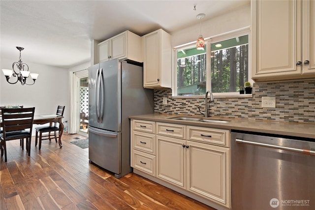 4909 95th Ave W, University Place, WA 98467 - kitchen with appliances with stainless steel finishes, a sink, cream cabinetry, tasteful backsplash, and a chandelier