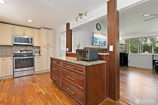 4909 95th Ave W, University Place, WA 98467 - kitchen featuring appliances with stainless steel finishes, cream cabinets, light wood-style flooring, light stone counters, and recessed lighting