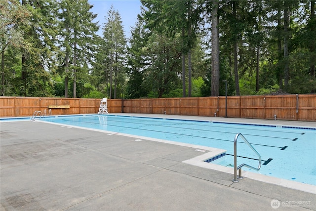 4909 95th Ave W, University Place, WA 98467 - view of swimming pool featuring fence and view of wooded area