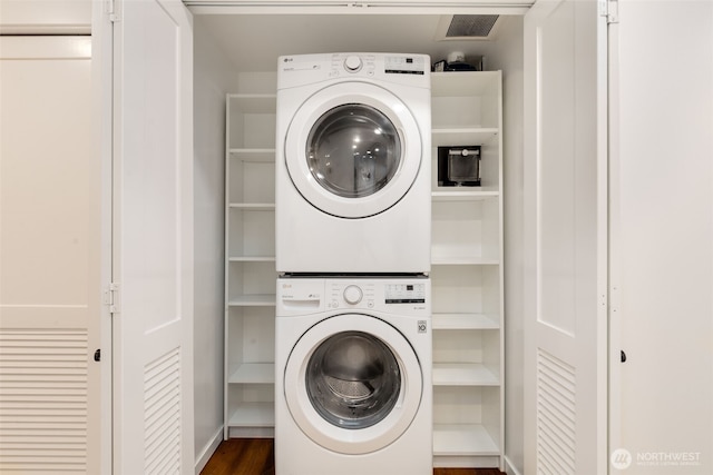 2721 1st Ave Unit 407, Seattle, WA 98121 - clothes washing area featuring stacked washer / dryer and dark wood-style floors