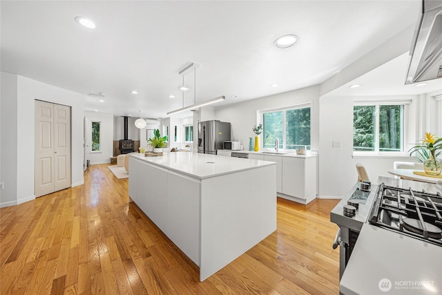 27923 NE 49th St, Redmond, WA 98053 - kitchen featuring appliances with stainless steel finishes, a sink, white cabinets, a kitchen island, and light countertops