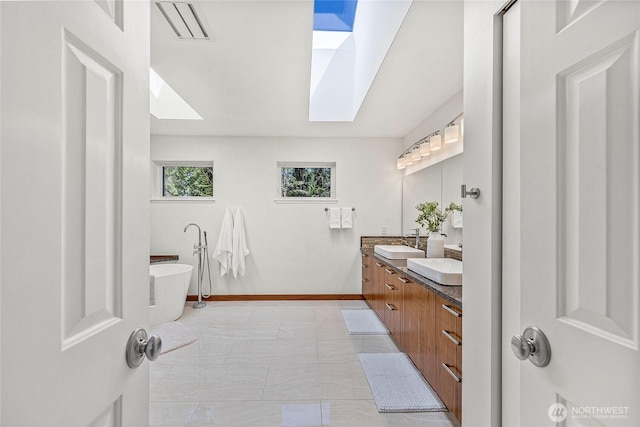 27923 NE 49th St, Redmond, WA 98053 - bathroom featuring a skylight, a soaking tub, baseboards, and double vanity