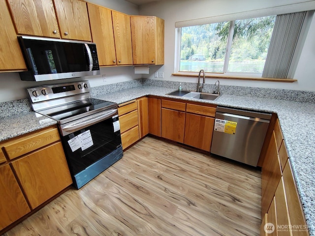 659 Cain Lake Rd, Sedro Woolley, WA 98284 - kitchen with appliances with stainless steel finishes, a sink, light wood finished floors, and brown cabinetry