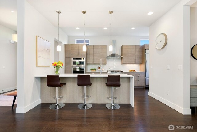 21955 SE 30th Pl, Sammamish, WA 98075 - kitchen with wall chimney range hood, stainless steel double oven, a kitchen bar, modern cabinets, and recessed lighting