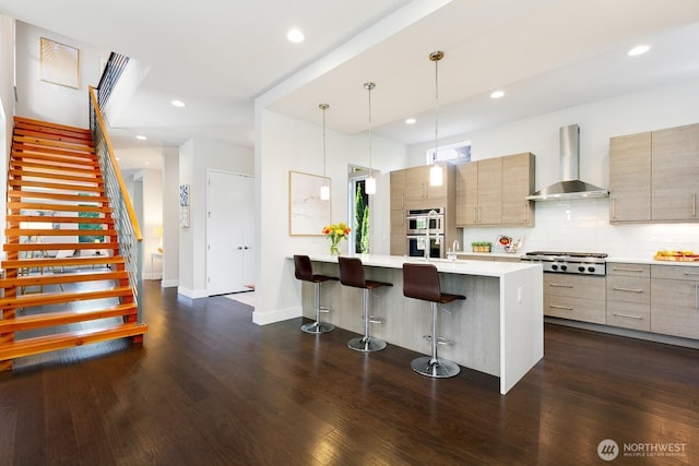 21955 SE 30th Pl, Sammamish, WA 98075 - kitchen with wall chimney exhaust hood, modern cabinets, stainless steel appliances, a breakfast bar, and recessed lighting