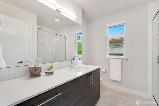 21955 SE 30th Pl, Sammamish, WA 98075 - bathroom featuring a stall shower, vanity, toilet, baseboards, and tile patterned flooring