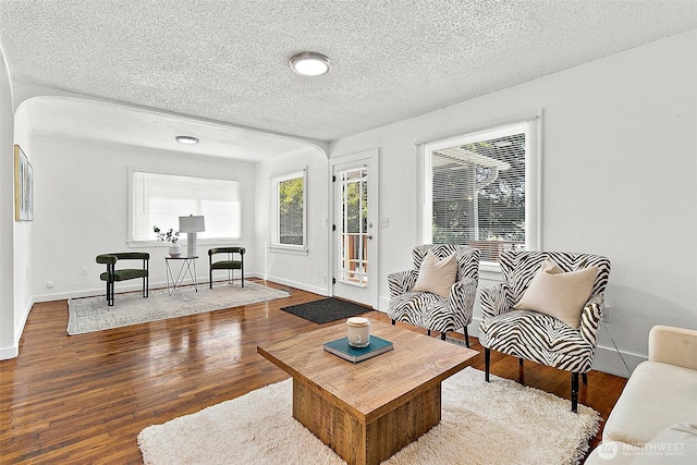 9819 Park Ave S, Tacoma, WA 98444 - living area with wood finished floors, a textured ceiling, arched walkways, and baseboards