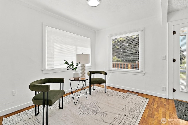 9819 Park Ave S, Tacoma, WA 98444 - living area featuring healthy amount of natural light, baseboards, wood finished floors, and ornamental molding