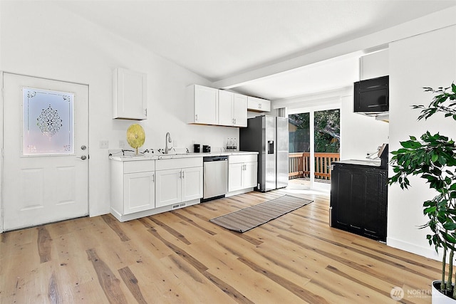 9819 Park Ave S, Tacoma, WA 98444 - kitchen with stainless steel appliances, light countertops, light wood-type flooring, and white cabinets