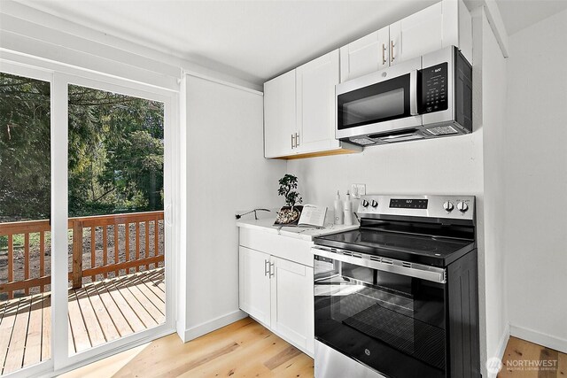 9819 Park Ave S, Tacoma, WA 98444 - kitchen with appliances with stainless steel finishes, light wood-type flooring, white cabinetry, and baseboards
