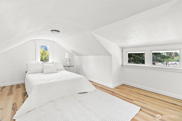 9819 Park Ave S, Tacoma, WA 98444 - bedroom with lofted ceiling, baseboards, light wood finished floors, and a textured ceiling