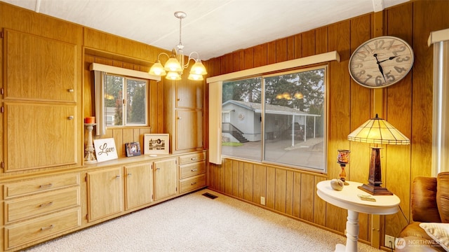 2101 S 324th St Unit 9, Federal Way, WA 98003 - dining room featuring wooden walls, a chandelier, and light carpet