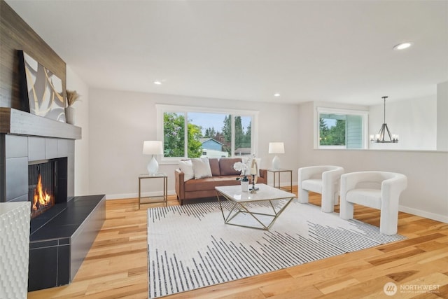 429 217th Pl SW, Bothell, WA 98021 - living room with baseboards, light wood-type flooring, a tiled fireplace, recessed lighting, and a chandelier