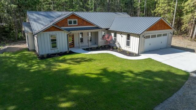 2075 NW Peterson Rd, Poulsbo, WA 98370 - view of front of house featuring board and batten siding, a garage, concrete driveway, a standing seam roof, and covered porch