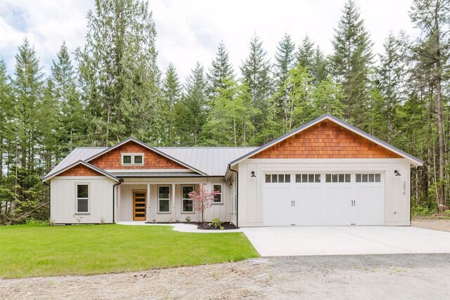 2075 NW Peterson Rd, Poulsbo, WA 98370 - view of front of home featuring a front yard, a garage, board and batten siding, concrete driveway, and metal roof