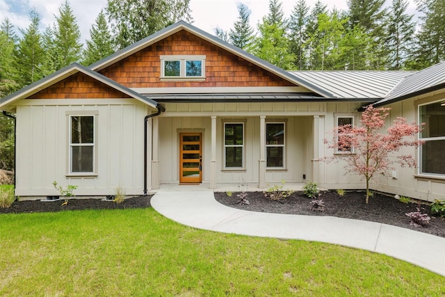 2075 NW Peterson Rd, Poulsbo, WA 98370 - view of front of house with board and batten siding, a front yard, covered porch, a standing seam roof, and metal roof