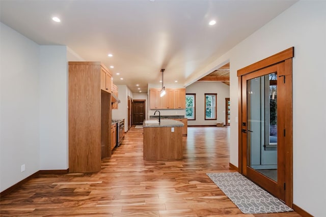 2075 NW Peterson Rd, Poulsbo, WA 98370 - kitchen with light wood-type flooring, baseboards, recessed lighting, light brown cabinets, and a kitchen island with sink