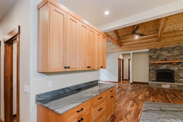 2075 NW Peterson Rd, Poulsbo, WA 98370 - kitchen featuring light brown cabinetry, dark wood-type flooring, ceiling fan, a stone fireplace, and stone countertops