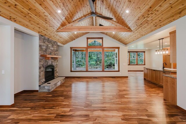 2075 NW Peterson Rd, Poulsbo, WA 98370 - unfurnished living room with light wood-style floors, a stone fireplace, a sink, high vaulted ceiling, and recessed lighting