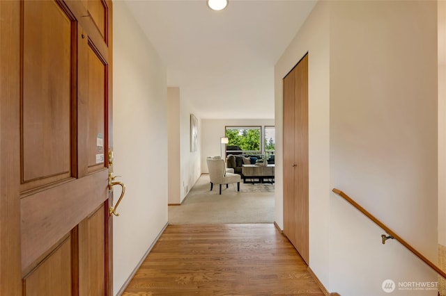 hallway featuring light wood-style floors and an upstairs landing