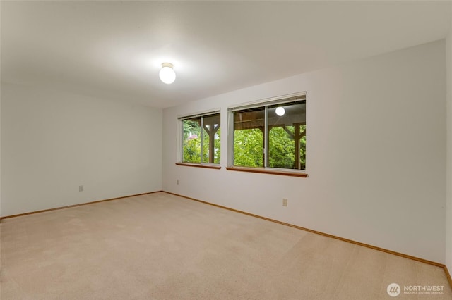 empty room featuring carpet floors and baseboards
