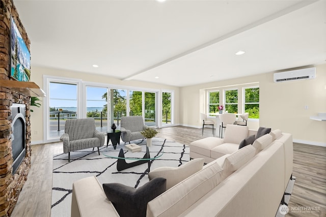 691 N W Camano Dr, Camano Island, WA 98282 - living room featuring a wall mounted AC, wood finished floors, baseboards, a fireplace, and recessed lighting