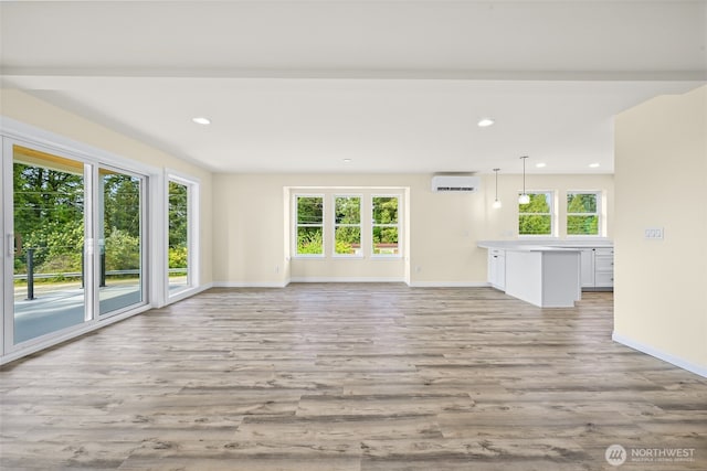 691 N W Camano Dr, Camano Island, WA 98282 - unfurnished living room with a wall unit AC, baseboards, light wood finished floors, and recessed lighting