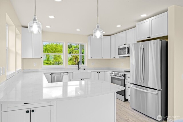 691 N W Camano Dr, Camano Island, WA 98282 - kitchen featuring stainless steel appliances, a sink, a peninsula, white cabinetry, and recessed lighting