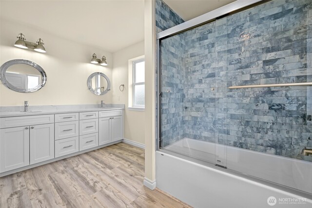 691 N W Camano Dr, Camano Island, WA 98282 - full bathroom featuring bath / shower combo with glass door, double vanity, wood finished floors, and baseboards